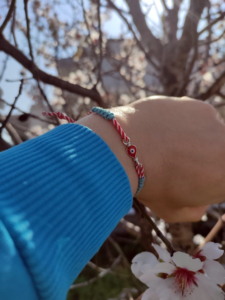 Zwyczaj zakładania czerwono białych obrączek na rękę w marcu.